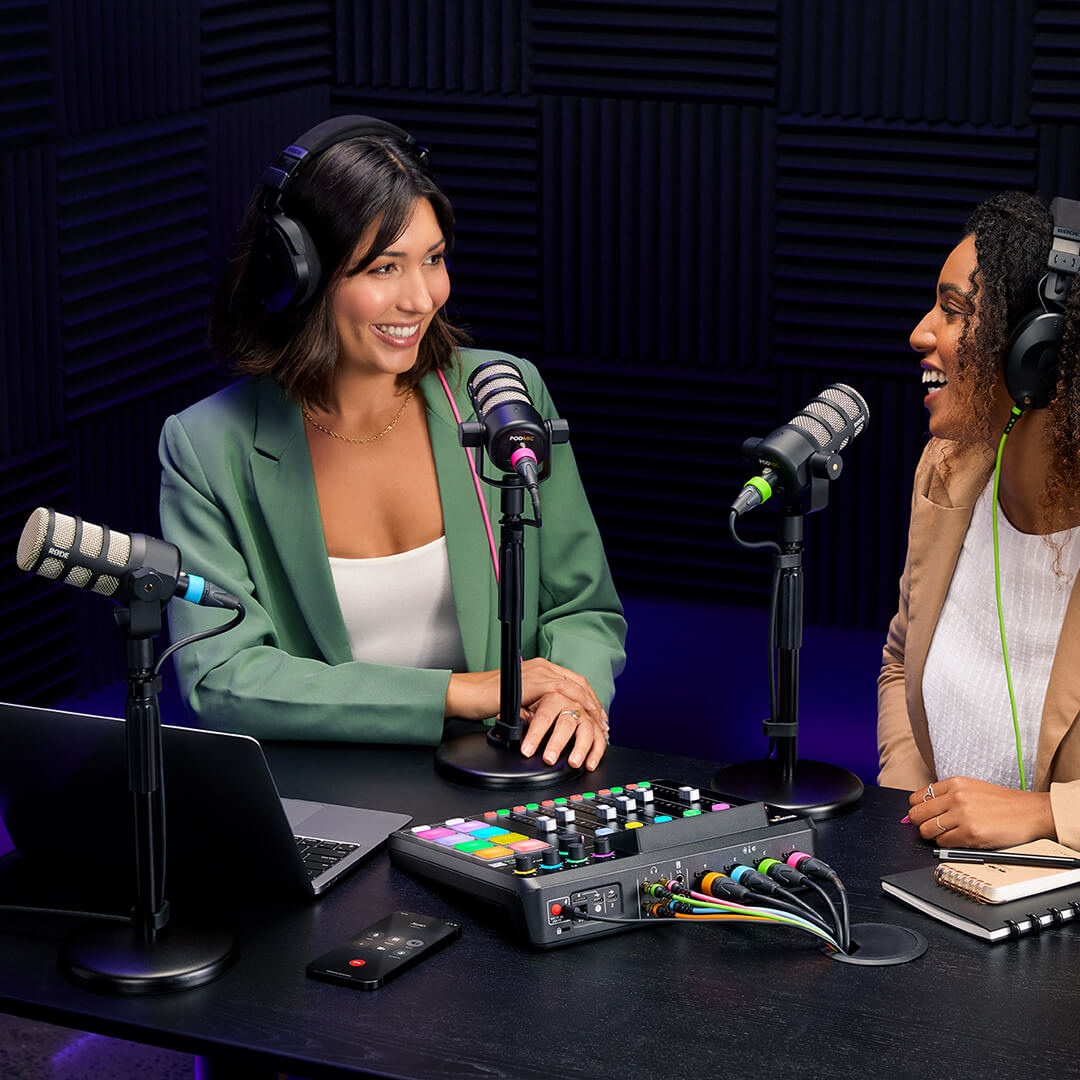 Two people recording podcast with PodMics mounted to DS1s and using RØDECaster Pro II